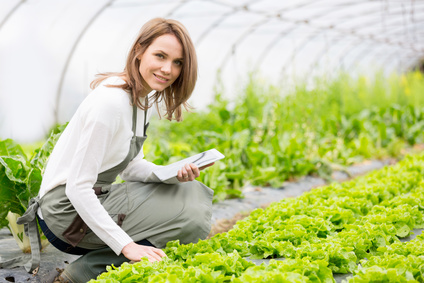 Portrait of an attractive farmer in a greenhouse using tablet